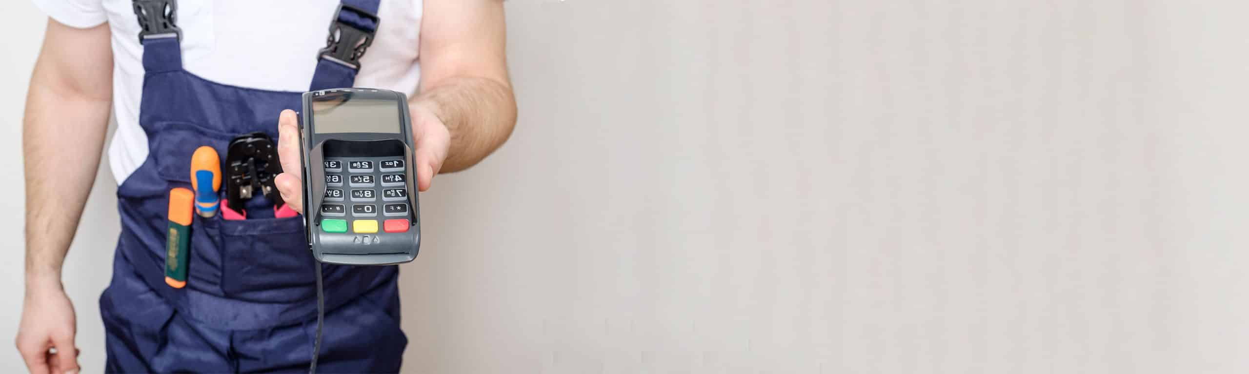 Hombre sostiene en sus manos un datafono