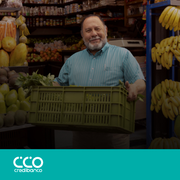 Hombre frente a su tienda de frutas y verduras